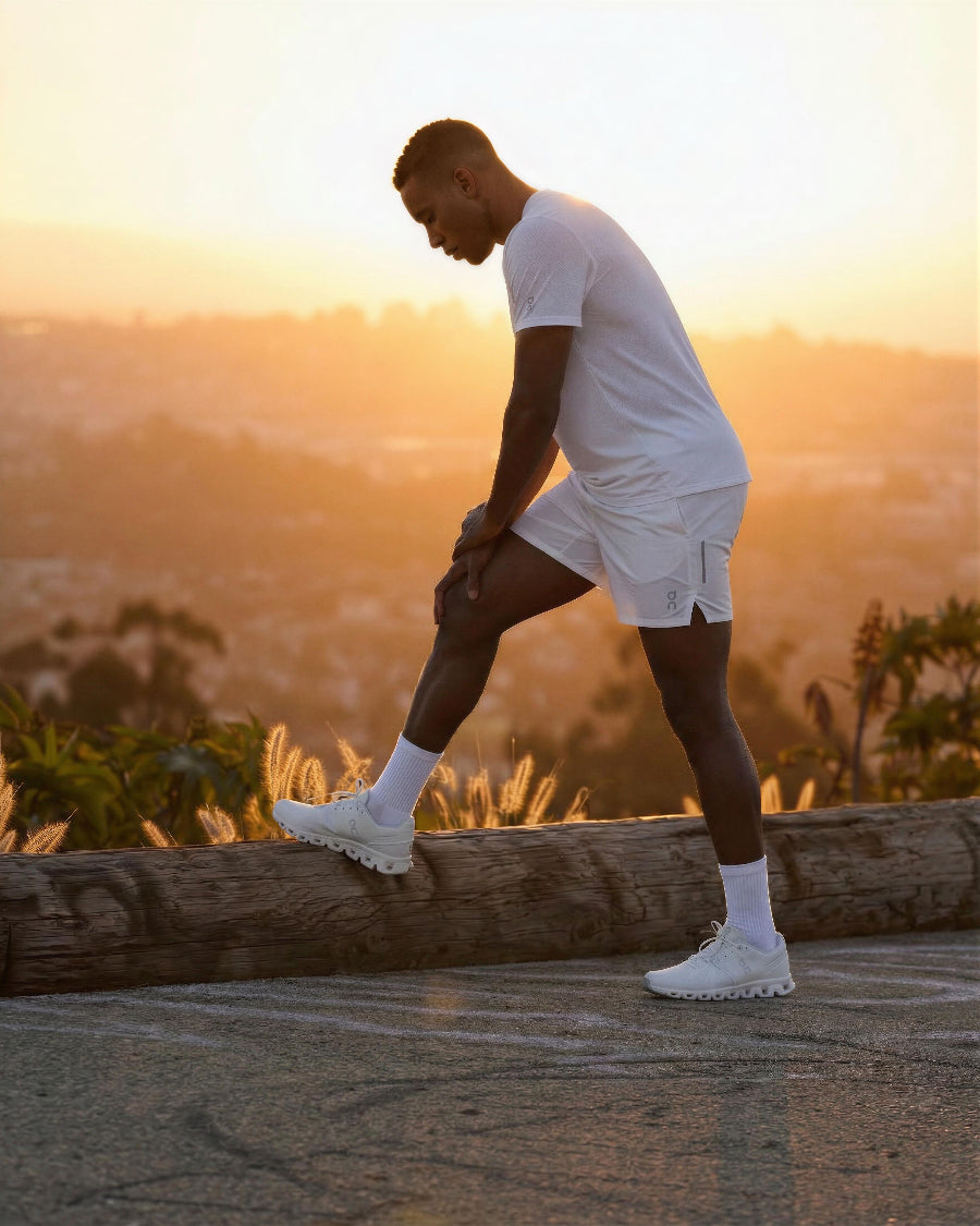 Person stretching outdoors with a scenic background during sunset